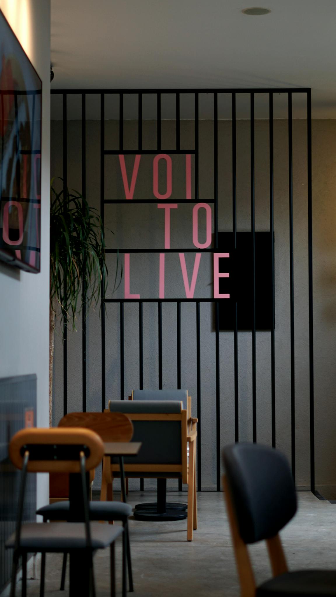 Contemporary cafe interior with chairs and decor, featuring motivational text on wall.